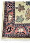 Border detail of a Persian Farahan rug with salmon pink ground, vine motifs, and navy floral accents