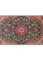 Detailed view of Persian Isfahan rug midfield with scrolling ivory vines and multicolor floral motifs on green