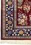 Side border view of Persian Isfahan rug showing navy background and floral medallions