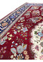 Color close-up of Persian Isfahan rug highlighting burgundy red, ivory, navy, and pastel floral tones