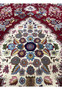 Inner medallion detail of Persian Isfahan rug with symmetrical floral design and silk accents