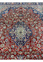 Central medallion detail of antique Kashan rug with navy and ivory floral design