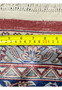 Backside of antique Persian Kashan rug with ruler showing knot scale, density, and weaving precision