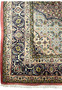 Wide border detail of Persian Bijar iron rug showing navy ground with floral medallions and precise hand-knotted outlines