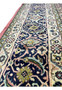 Side border view of Persian Bijar iron rug with scrolling vines, floral rosettes, and crisp color contrast