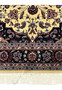Lower border detail of Persian Tabriz rug with repeating floral rosettes on navy groun