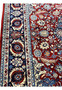 Border closeup of Persian Tabriz rug showing navy main border, light blue guard borders, and ivory floral elements