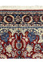 Upper end border detail of Persian Tabriz rug with navy floral border band, ivory accents, and fringe at the top