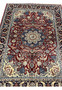 Close view of burgundy field on Persian Tabriz rug with floral vines, palmettes, and light blue and ivory details