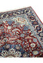 Upper edge of 5'6 x 8 Persian Tabriz rug with burgundy field, navy blue border, ivory floral guard bands, and white hand-knotted fringe