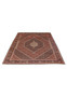Bijar Persian iron rug laid on floor displaying dense geometric field, red ground, and symmetrical medallion design