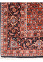 Detailed view of Bijar Persian iron rug border with repeating floral motifs on dark navy background