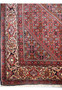 Persian Bijar rug border featuring floral motifs in red, ivory, and dark navy