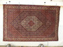 Persian Bijar iron rug hanging display showing dense weave and geometric medallion design