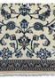 Lower border detail of Persian Nain rug with layered blue floral motifs and fine outlines