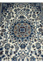 Close-up of blue medallion with floral motifs on ivory field in hand knotted Persian Nain rug