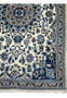 Detailed border view showing navy blue floral arabesques on Persian Nain rug