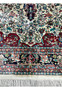 Lower border detail of silk oriental rug with floral motifs and rich colors
