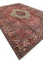 Angled view of a large Persian Bijar iron rug showing diamond medallion layout, dense red field, and heavy wool structure