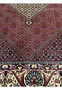 Overall pattern detail highlighting symmetrical geometric layouts across the red field of a Persian Bijar rug