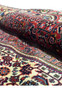 Rolled view showing the firmness and weight of a tightly woven Persian Bijar iron rug