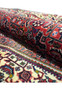 Texture detail of a rolled Persian Bijar rug showing dense wool pile and compact construction