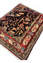 Angled perspective of antique Nahavand tribal rug highlighting depth, pile texture, pictorial motifs, and saturated indigo field