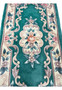 Macro view of raised floral scrollwork on Aubusson Art Deco rug highlighting sculpted weaving and dimensional surface texture