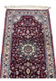Midfield detail of a Persian Tabriz rug featuring layered floral motifs, soft blue and blush accents, and dense hand-knotted wool on a burgundy ground