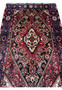 Midfield detail of a Persian Gholtogh rug highlighting layered tribal motifs, saturated red tones, black outlines, and dense wool pile