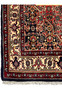Border detail of a Persian Bijar rug showing repeating floral motifs, ivory ground, navy outlines, and precise hand-knotted craftsmanship