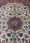 Close view of the central field of a Persian Isfahan rug highlighting detailed floral motifs, silk accents, soft ivory tones, and precise kork wool knotting