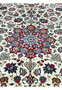 Closeup of the central medallion on a Persian Isfahan rug featuring layered floral geometry, silk highlights, ivory field, and precise kork wool weaving.