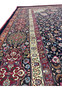 Side border view of Persian Mashad rug featuring complex floral motifs, crisp outlines, silk accents, and elegant color transitions along the edge.