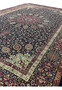 Angled perspective of Persian Mashad rug revealing pile depth, silk sheen, structured borders, and overall scale of this signed Sheshkalani masterpiece.