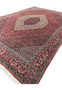 Angled view of a Persian Bijar iron rug emphasizing its firm construction, thick wool pile, geometric clarity, and strong architectural presence