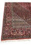 Border close-up of a Persian Bijar iron rug showing compact knot structure, crisp outlines, layered design bands, and rich traditional colors