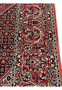Border closeup of a Persian Bijar iron rug highlighting layered floral borders, deep red ground, navy accents, ivory details, and heavy wool construction