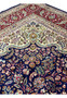 Upper edge view of a Persian Tabriz rug with crisp borders, balanced proportions, and finely woven floral elements