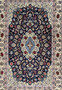 Midfield detail of super fine Persian Isfahan rug highlighting navy ground, scrolling floral vines, silk highlights, and precise hand knotted detailing