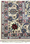 Persian Isfahan rug border featuring layered floral bands in ivory, sky blue, burgundy red, navy, and soft beige with precise wool and silk detailing