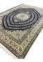 Angled view of Persian Nain 6 La rug highlighting depth, silk sheen, and detailed floral design across navy field