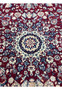 Central medallion close up of Persian Tabriz rug with burgundy field, ivory starburst design, navy blue outlines, and fine wool texture