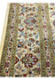 Detailed border section of a Persian Qum silk rug featuring repeating floral rosettes, curved vines, and crisp color separation in pure silk.