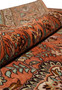 Rolled view of a signed Paradies Persian Tabriz rug highlighting soft kork wool texture, warm terracotta tones, garden motifs, and flexible hand-knotted structure