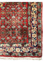 Border close-up of a Persian Sarough rug displaying navy floral patterns, ivory accents, and traditional geometric framing elements