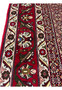 Border close-up of Persian Senneh rug featuring floral medallions, vine elements, red and ivory palette, and sharply articulated outlines