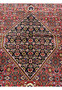 Central medallion close-up of Persian Bijar rug showcasing intricate geometric patterning, dark ground, and refined color detailing