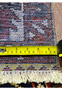 Backside measurement view of a Persian Bakhtiar garden rug showing scale, tight weaving, and hand-knotted wool construction with ruler for reference