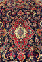Central medallion close up Persian Mahal rug ivory red and blue floral geometry on deep navy background.